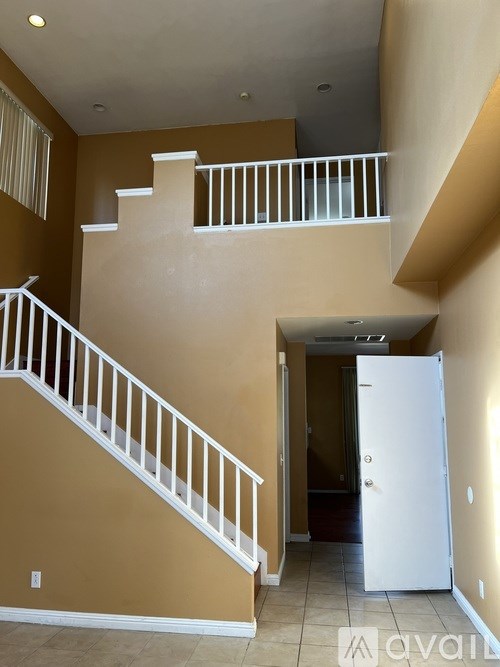 A white staircase with a white railing and a white door.