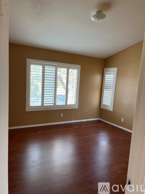 A room with brown walls and wooden flooring.