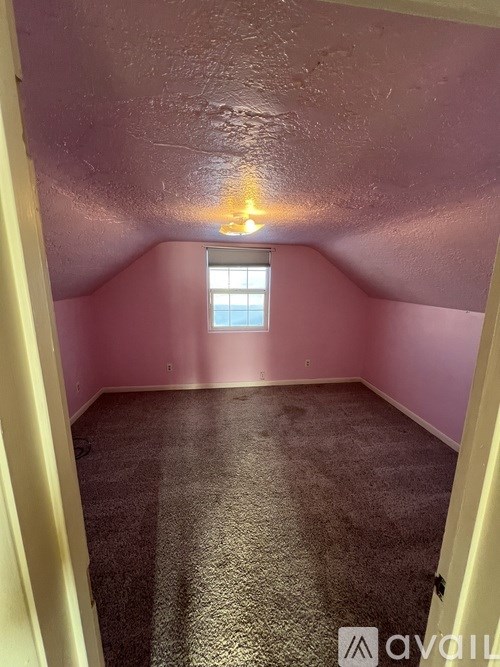 A room with a carpeted floor and a window.