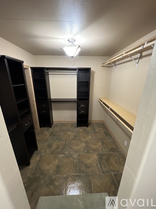 A hallway with a light on and a bench on the side.