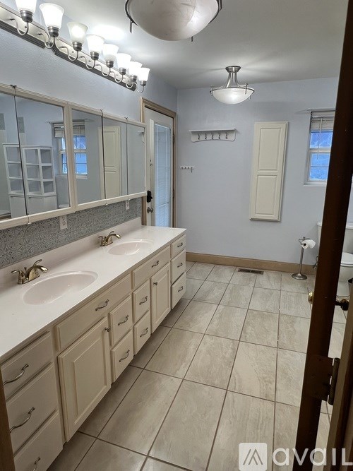 A bathroom with a sink, mirror, and light fixture.