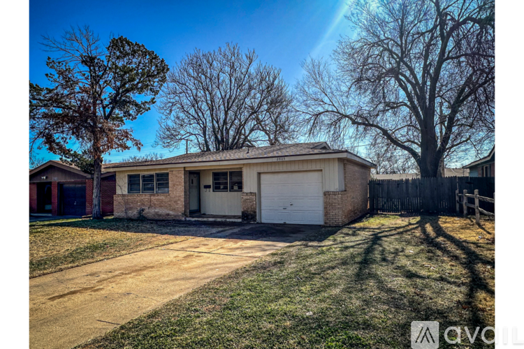 A house with a garage and a driveway in front of it.