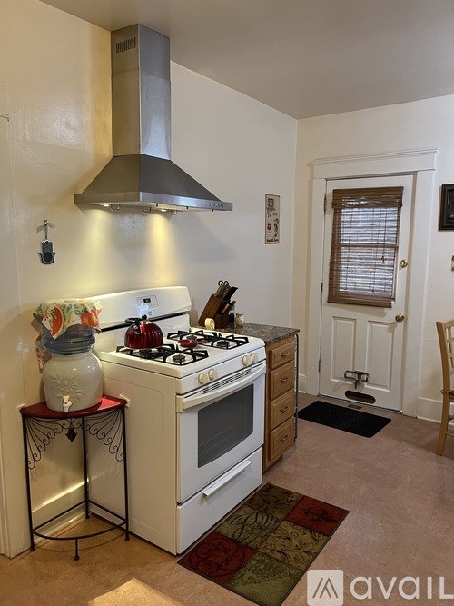 A kitchen with a stove and a hood.