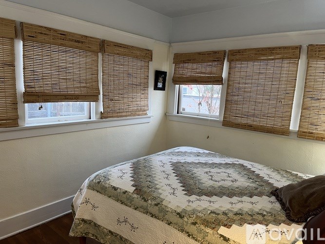 A bedroom with a bed and a window with wooden blinds.