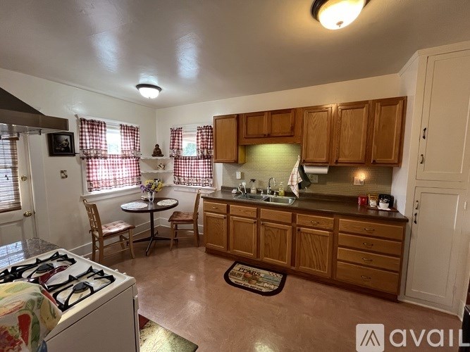 A kitchen with wooden cabinets and a white stove top oven.