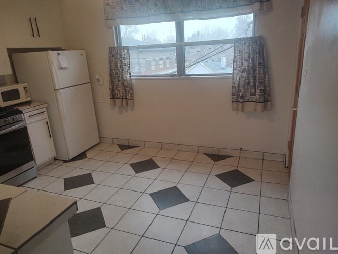 A kitchen with a white fridge, microwave, and oven.