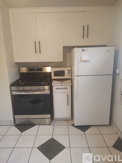 A kitchen with a white fridge, stove, and microwave.