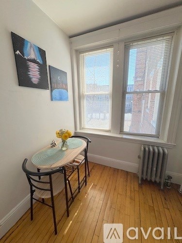 A room with a table and chairs and two pictures on the wall.