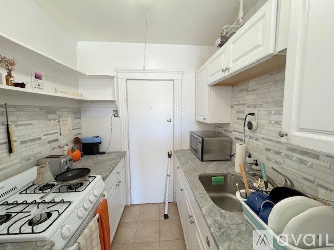 A kitchen with a white stove and a white door.