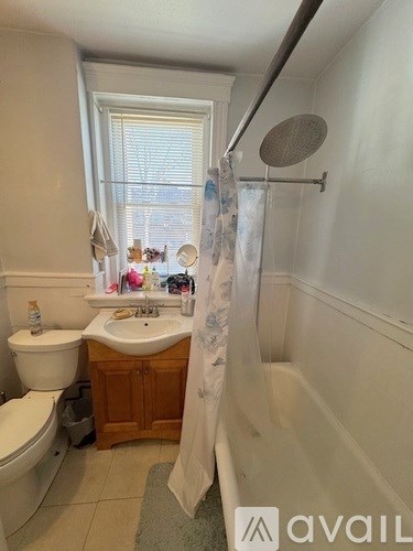 A bathroom with a toilet, sink, and shower.