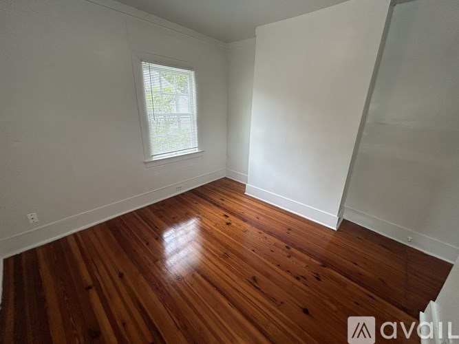 A room with wooden flooring and a window.