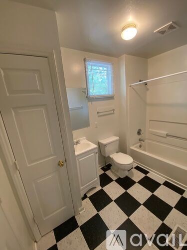 A white bathroom with black and white checkered floor.