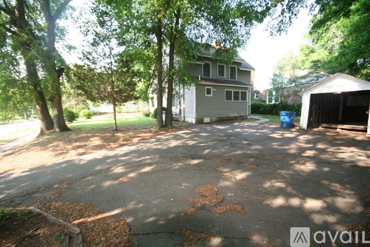 A house is surrounded by trees and has a driveway.