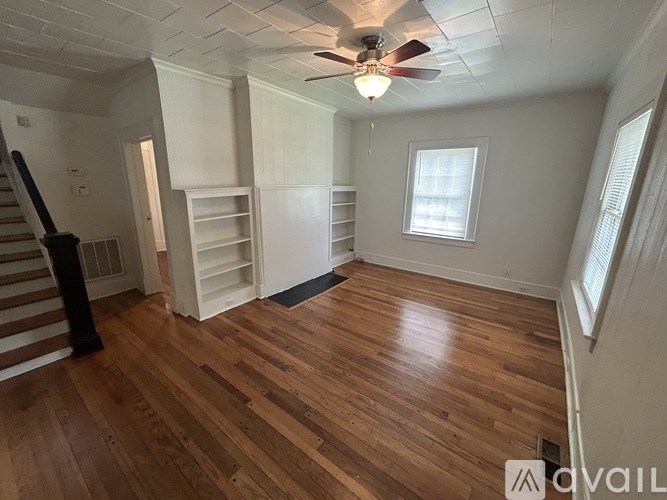 A room with wooden floors and a ceiling fan.