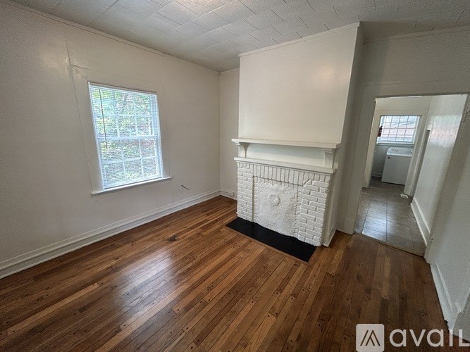 A room with wooden floors and a fireplace.