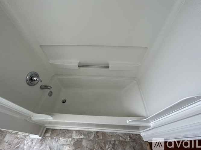 A white bathroom with a shower and a shower head.