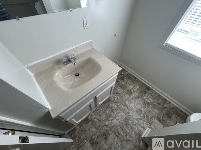 A bathroom with a stone floor and a white sink.