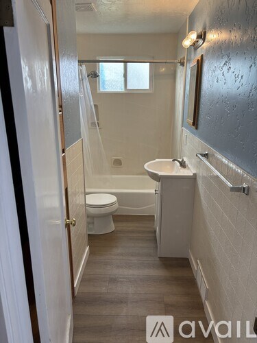 A bathroom with a toilet, sink, and bathtub.
