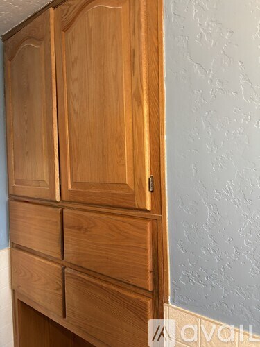 Brown wooden cupboards with drawers and a handle.