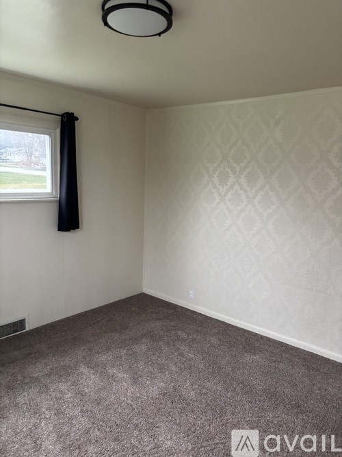 A wooden shelf unit is installed in a basement with pipes and ducts overhead.