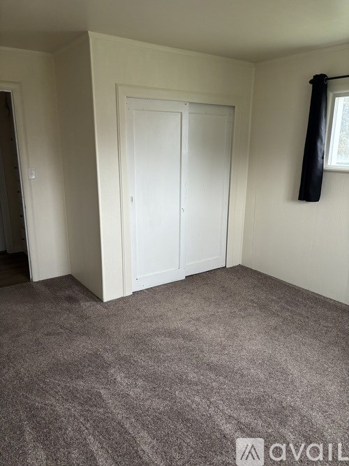 A hallway with wood paneling and a door at the end.