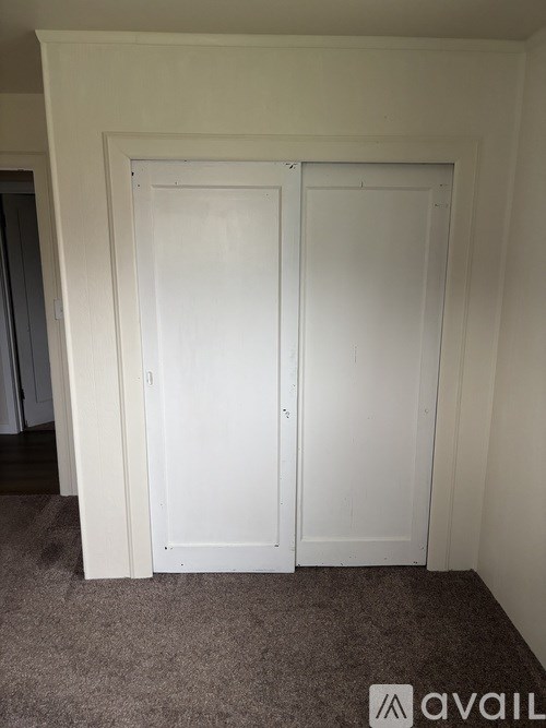 A room with wooden paneling and a white door.