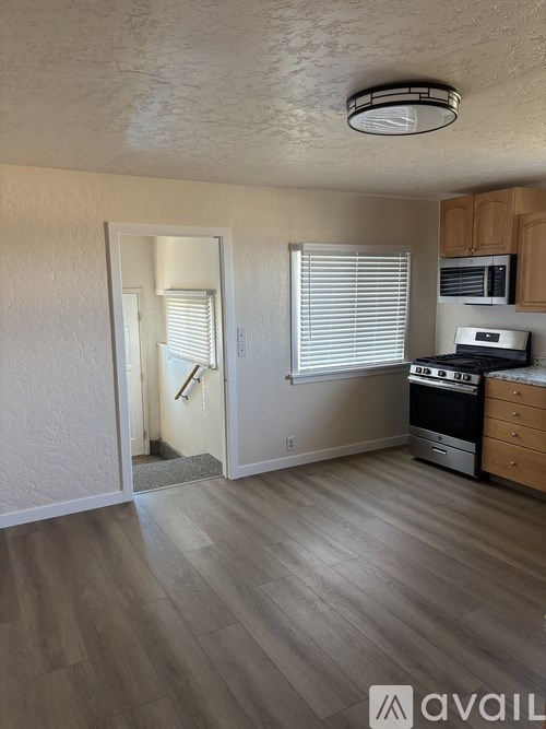 A kitchen with wooden cabinets and a stove top oven.