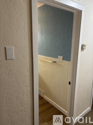 A white door with a light switch on the wall.