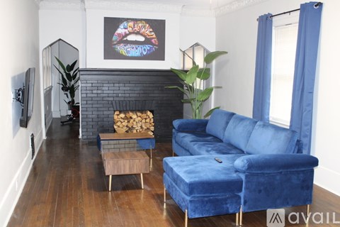A living room with a blue couch and a fireplace.