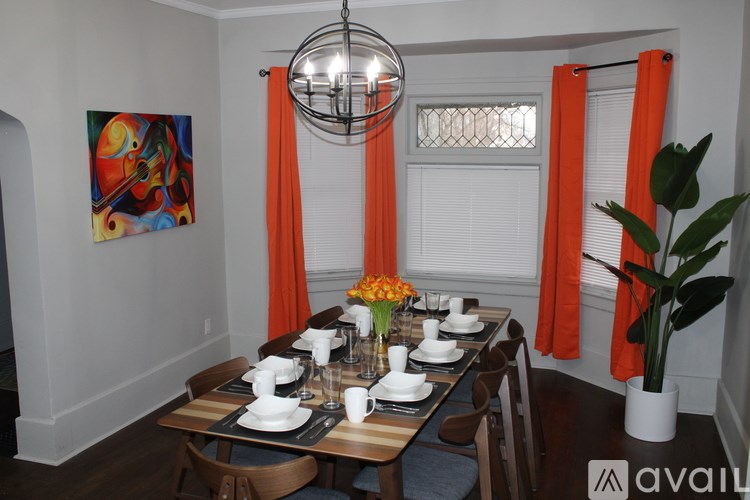 A dining room with a wooden table set for a meal.