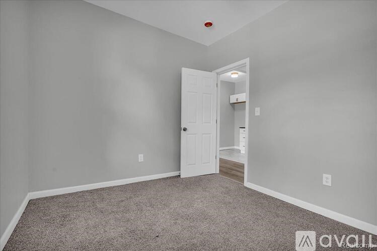 A room with a carpeted floor and a white door.