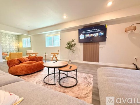 A living room with a television on the wall and a sofa.