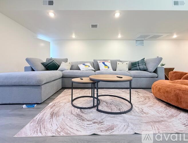 A living room with a grey couch, a round coffee table, and a rug.