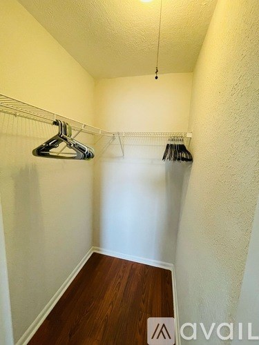 A small closet with a hanger and clothes on it.