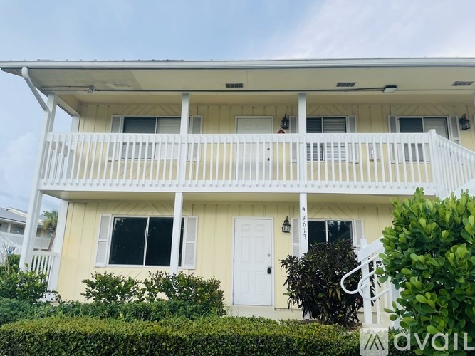 A white house with a balcony and a white door.