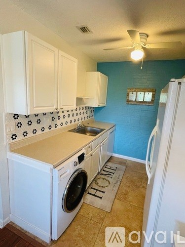 A small kitchen with a washing machine built into the counter.