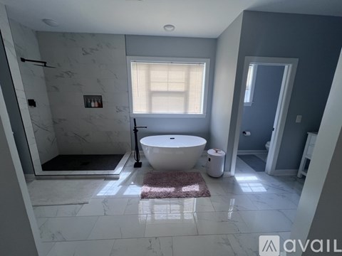 A bathroom with a marble floor and a round bathtub.