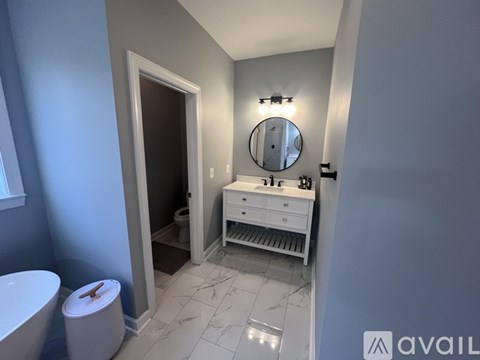 A bathroom with a toilet, sink, and mirror.