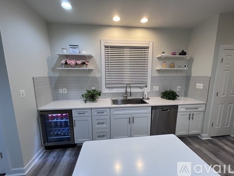A kitchen with white cabinets and a white countertop.