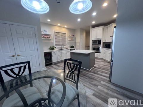 A modern kitchen with a glass table and chairs.