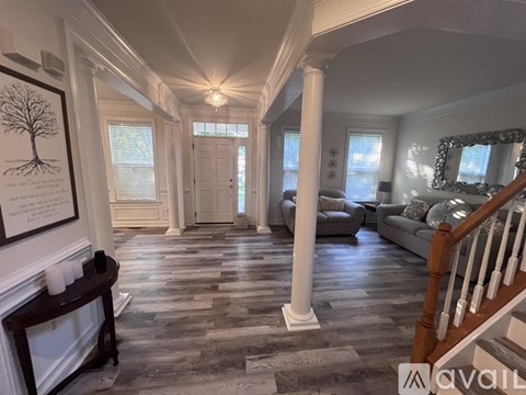 A hallway with a tree drawing on the wall and a mirror on the right.