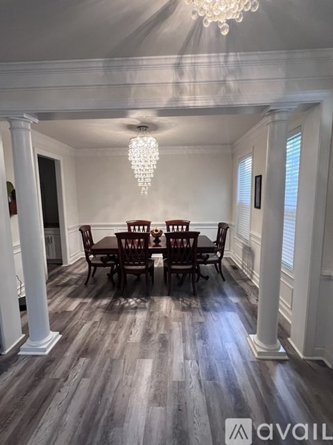 A dining room with a wooden table and chairs.