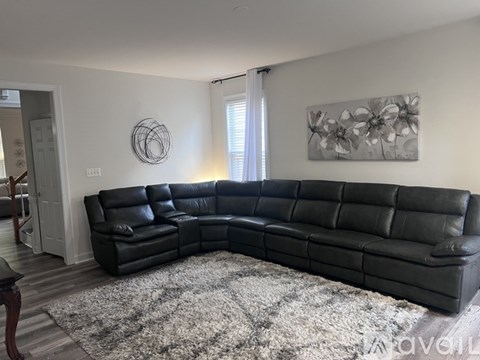 A black leather sectional sofa in a living room.
