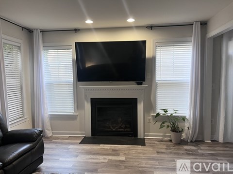 A living room with a fireplace and a flat screen TV mounted above it.