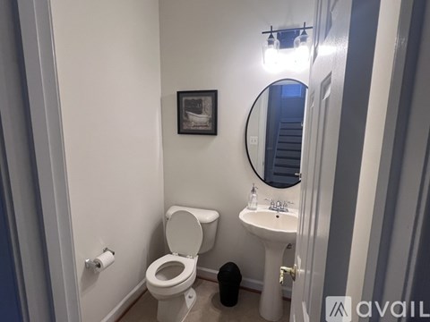 A bathroom with a toilet, sink, and mirror.