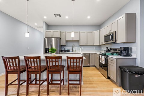 A kitchen with wooden chairs and a counter.