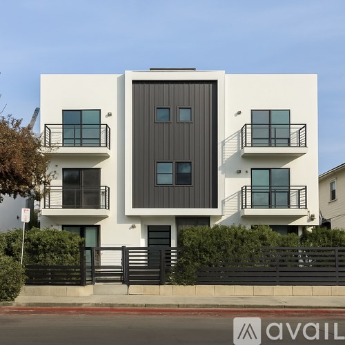 A modern two-story house with a black front door and balconies.