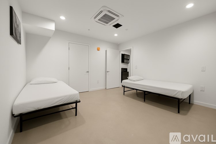 A room with two single beds and a small shelf.