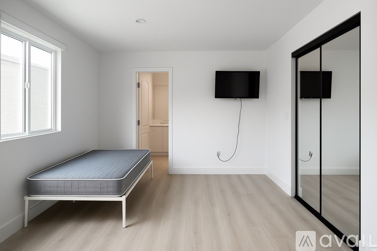 A bedroom with a bed, mirror, and television.