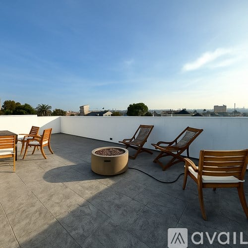 A patio with chairs and a table with a planter on it.